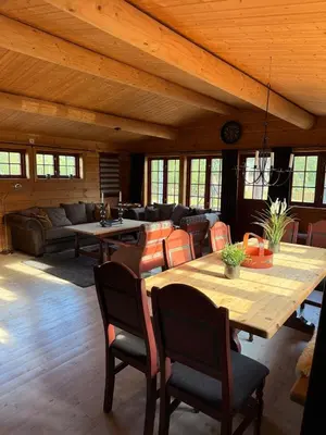 a living room with a wooden table and chairs at Spacious mountain cabin in Valdres with 3 bedrooms in Vevle