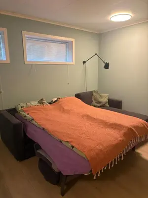 a bedroom with a bed with an orange blanket on it at Resting in Sauda