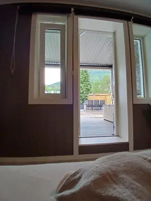 a bedroom with two windows and a view of a porch at Apartment in Stryn in Stryn