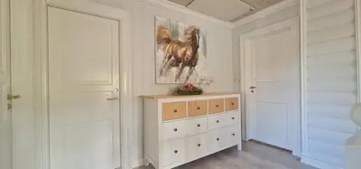 a room with a dresser and a painting of a horse at Waterfront Villa Boat Included, Near Bergen in Lindås