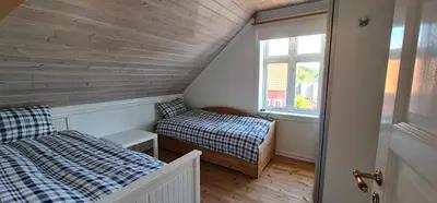 a attic room with two beds and a window at Waterfront Villa Boat Included, Near Bergen in Lindås