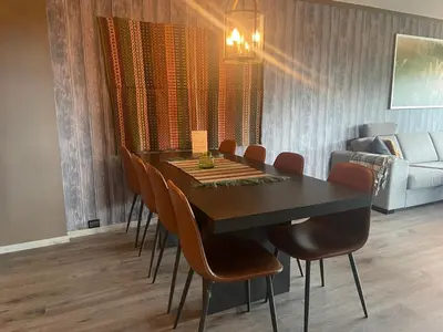 a dining room with a table and chairs and a couch at Modern 4-Bedroom Apartment in Beitostøl