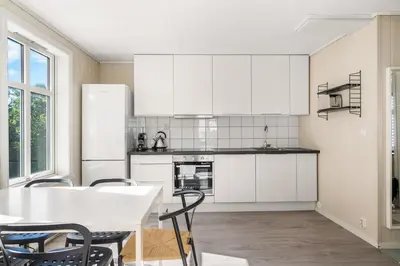 a kitchen with white cabinets and a table and chairs at Charming Townhouse - Walk Everywhere! in Bergen