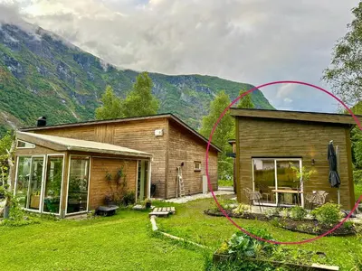 a house with a red hose in front of it at Flåm Tinyhouse with a Waterfall View in Flåm