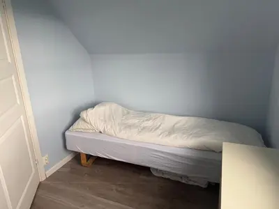 an unmade bed in a corner of a room at Nylendo in Ulvik