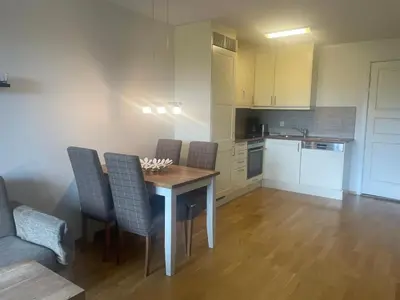 a kitchen with a table and chairs in a room at Sentral, Hc-Friendly Apartment in Beitostøl