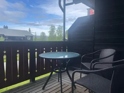 a patio with a table and chairs on a balcony at Sentral, Hc-Friendly Apartment in Beitostøl