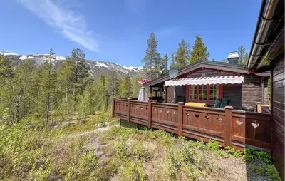 a log cabin with a deck in the woods at 3 Bedroom Gorgeous Home In Nordberg in Nordberg