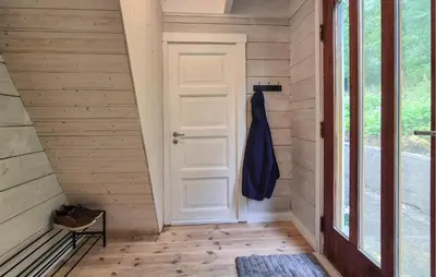 a hallway with a white door and a bench at Nice Home In Aksdal With House Sea View in Aksdal