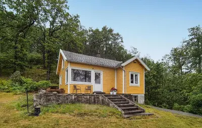 a small yellow tiny house with a set of stairs at Nice Home In Aksdal With House Sea View in Aksdal