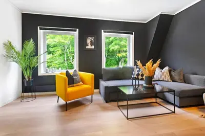 a living room with a couch and a yellow chair at Townhouse with free parking in the city centre - 4 bedrooms in Ålesund