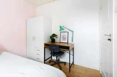 a bedroom with a desk with a chair and a bed at Townhouse with free parking in the city centre - 4 bedrooms in Ålesund
