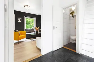 a bathroom with a toilet and a yellow chair at Townhouse with free parking in the city centre - 4 bedrooms in Ålesund