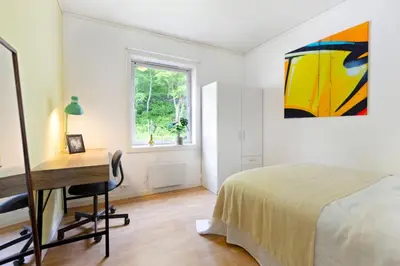a bedroom with a desk and a bed and a window at Townhouse with free parking in the city centre - 4 bedrooms in Ålesund