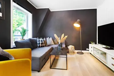 a living room with a couch and a tv at Townhouse with free parking in the city centre - 4 bedrooms in Ålesund