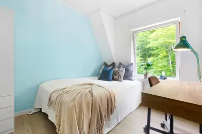 a bedroom with a bed with a blanket on it at Townhouse with free parking in the city centre - 4 bedrooms in Ålesund