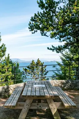 a picnic table with a view of the water at Large apartment with 5 bedrooms, 2 bathrooms and roof terrace in Ålesund