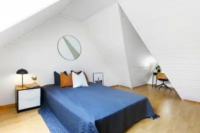 a bedroom with a blue bed in a attic at City apartment with 4 bedrooms & private terrace in Ålesund