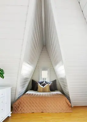 a bedroom with a bed in a white attic at City apartment with 4 bedrooms & private terrace in Ålesund