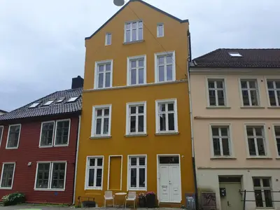 a yellow building next to two other buildings at You cottage in the city in Bergen