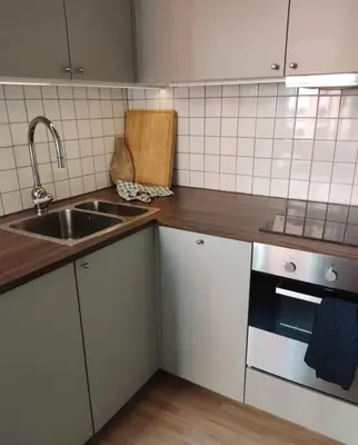 a kitchen with white cabinets and a sink at You cottage in the city in Bergen