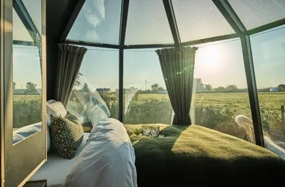a bedroom with a bed and a large window at Stangeland Gard in Austevoll