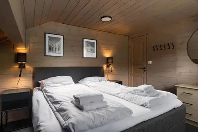 a large bed with white sheets and towels on it at 4-Bedroom Ski-In Family Cabin at Geilolia hyttetun in Hol