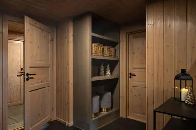 a walk in closet with wooden walls and doors at 4-Bedroom Ski-In Family Cabin at Geilolia hyttetun in Hol