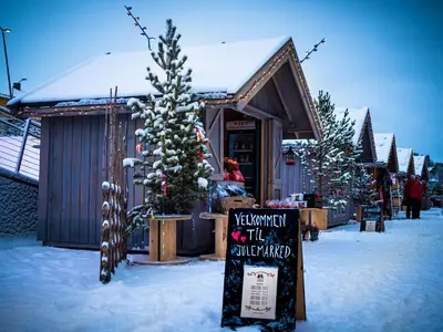 a store with a christmas tree and a sign in the snow at 4-Bedroom Ski-In Family Cabin at Geilolia hyttetun in Hol