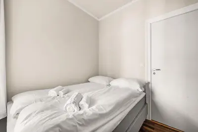 a white bed with white sheets and pillows on it at BB Apartments I 300m to Bryggen & Train Station in Bergen