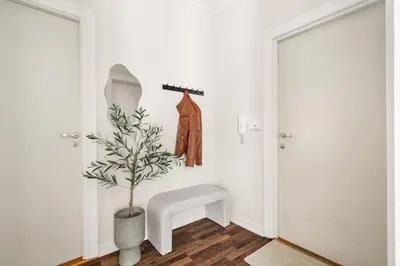 a hallway with a plant in a vase next to a door at BB Apartments I 300m to Bryggen & Train Station in Bergen