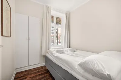 a white bedroom with a bed and a window at BB Apartments I 300m to Bryggen & Train Station in Bergen