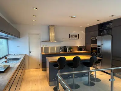 a kitchen with a counter and some black appliances at Exclusive seafront villa in Ålesund