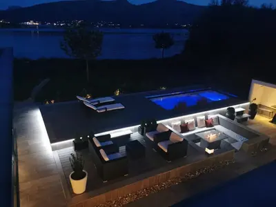 a backyard with a pool at night at Exclusive seafront villa in Ålesund