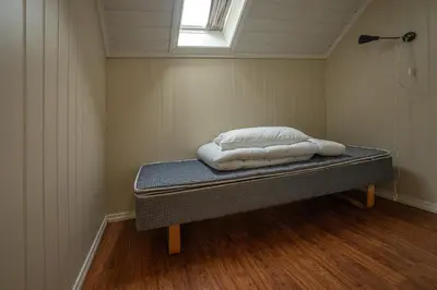 a small room with a bed with two pillows on it at Seljevaagen Penthouse in Selje