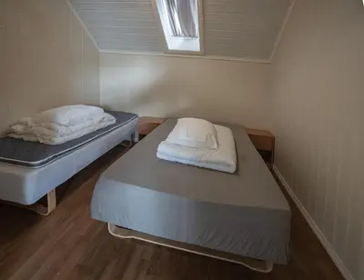 two beds in a small room with a window at Seljevaagen Penthouse in Selje