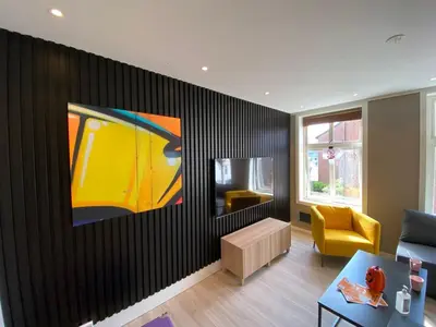 a living room with a painting on the wall at 4 bedroom apartment in Ålesund City in Ålesund