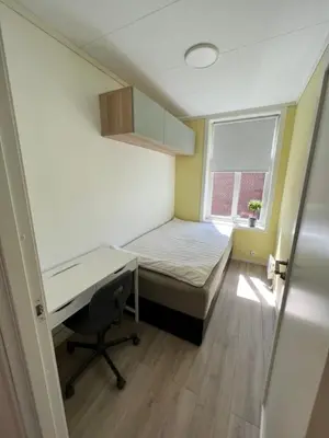 a bedroom with a bed and a desk and a window at 4 bedroom apartment in Ålesund City in Ålesund