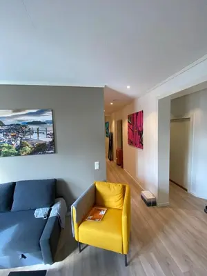 a living room with a couch and a yellow chair at 4 bedroom apartment in Ålesund City in Ålesund