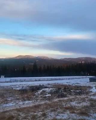 a snowy field with a road and mountains in the background at Synnseter, Synnfjellet, Fjellstuguvegen 38, 2880 Nord Torpa in Lii