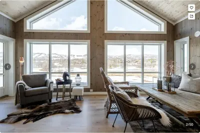 a living room with a table and chairs and windows at Modern Mountain Escape in Beitostøl