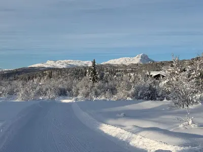 a road covered in snow with mountains in the background at Modern Mountain Escape in Beitostøl