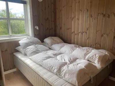 a unmade bed in a room with a window at Modern Mountain Escape in Beitostøl