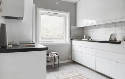 a kitchen with white cabinets and a window at Cozy apartment at Laksevåg! in Bergen