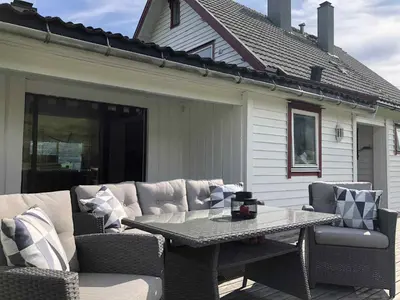 a patio with a table and chairs on a patio at Stall Rygg Apartment, Gloppen