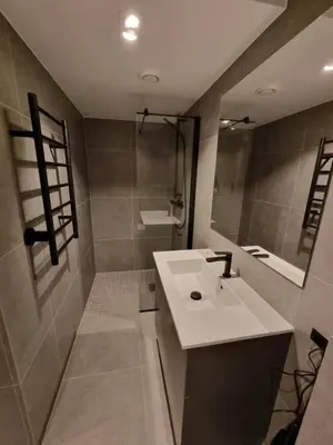 a bathroom with a white sink and a mirror at Central and Spacious Apartment for 6 in Trondheim