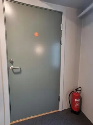 a door in a room with a fire extinguisher at Central Apartment for 4 in Trondheim