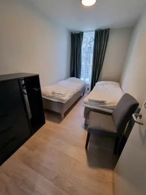 a small room with two beds and a chair at Central Apartment for 4 in Trondheim