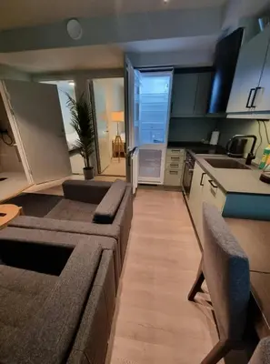 a large living room with a couch and a kitchen at Central Apartment for 4 in Trondheim