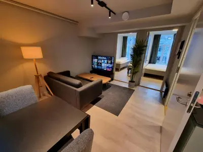 a living room with a couch and a table with a television at Central Apartment for 4 in Trondheim